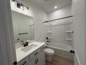 Bathroom featuring vanity, light wood-style floors,  shower combination, and recessed lighting