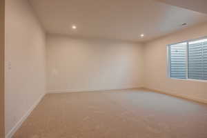 Empty room featuring light carpet and recessed lighting