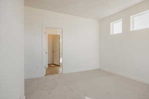 Spare room with light carpet and baseboards
