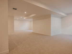 Finished below grade area featuring light carpet and recessed lighting