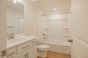 Bathroom with vanity, shower / bath combination, and light wood-style flooring