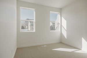 Spare room with light colored carpet and baseboards