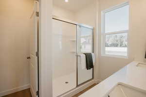 Full bathroom featuring a stall shower, double vanity, and recessed lighting