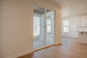 Empty room featuring light wood-type flooring and recessed lighting