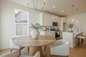 Dining room featuring light wood-style flooring and a chandelier
