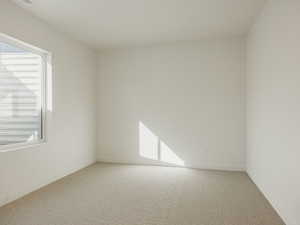 Carpeted empty room featuring baseboards