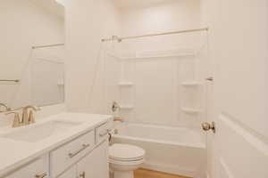 Full bathroom with vanity, washtub / shower combination, and light wood-type flooring