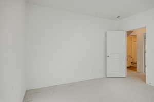Empty room with light carpet and baseboards