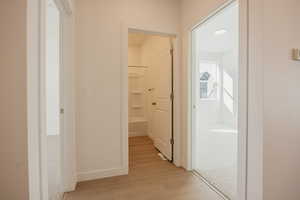 Hall featuring light wood-type flooring and baseboards