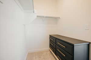 Walk in closet with light carpet