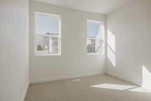 Spare room featuring baseboards and light colored carpet
