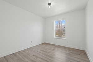 Unfurnished room featuring baseboards and light wood finished floors