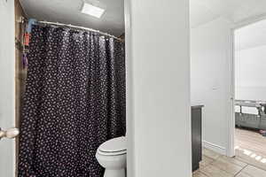 Full bath with a shower with shower curtain and a textured ceiling
