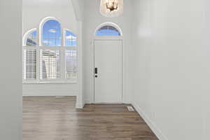 Foyer entrance with wood finished floors and baseboards