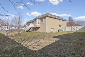Rear view of house with a gate, stucco siding, a mountain view, and roof with shingles