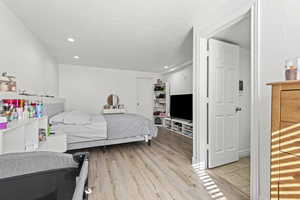 Bedroom with light wood-style floors, recessed lighting, and a textured ceiling