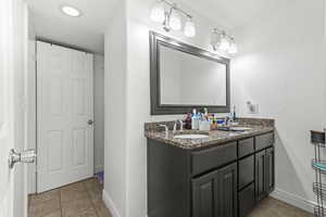 Full bathroom with double vanity and light tile patterned floors