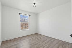 Unfurnished room with baseboards and light wood-style floors