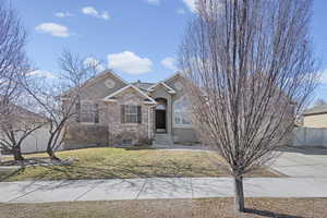 View of front facade featuring stone siding, stucco siding, and a gate