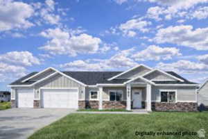 Craftsman house with a front yard, stone siding, a garage, and concrete driveway