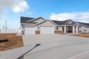 Craftsman house with an attached garage, covered porch, driveway, a shingled roof, and board and batten siding
