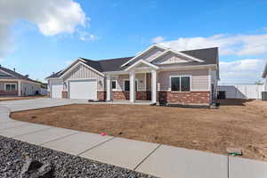 Craftsman inspired home featuring board and batten siding, covered porch, driveway, a garage, and brick siding