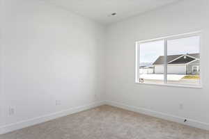 Spare room with baseboards and light carpet