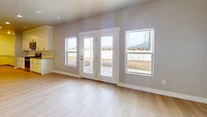 Kitchen with stainless steel appliances, light wood-type flooring, recessed lighting, and white cabinets