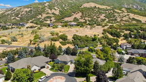 Aerial view of property's location with nearby suburban area and a mountainous background