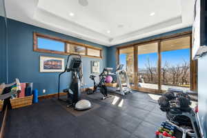 Exercise area with a tray ceiling and recessed lighting