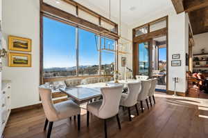 Dining area featuring a mountain view, suspended lighting, and dark wood-style flooring