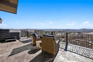 View of patio with a hot tub and a mountain view