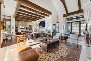 Living area with a large fireplace, dark wood-style flooring, and lofted ceiling