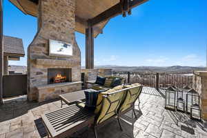 View of patio featuring an outdoor living space with a fireplace and a mountain view