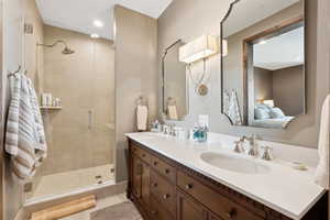 Full bath featuring double vanity, a shower stall, ensuite bathroom, and recessed lighting