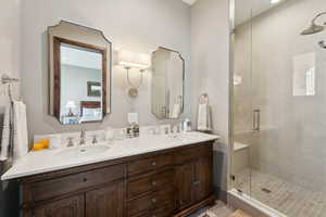Bathroom with double vanity, a stall shower, connected bathroom, and recessed lighting