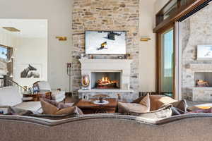 Living area featuring a stone fireplace and wood finished floors
