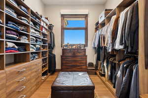 Walk in closet with light wood-type flooring