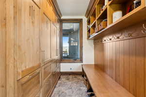 Mudroom with stone finish floors and baseboards