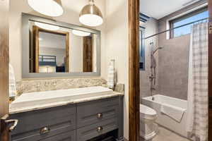 Full bathroom with shower / tub combo with curtain and vanity