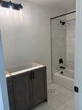 Full bath with vanity,  shower combination, and light marble finish floors