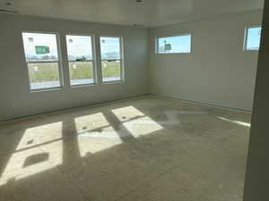 Unfurnished room with concrete flooring and healthy amount of natural light