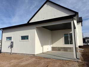 Rear view of house with a patio and stucco siding