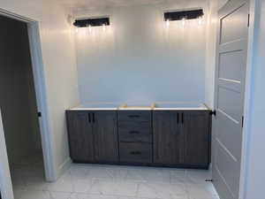 Full bath featuring light marble finish flooring and double vanity