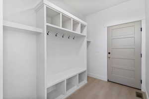 Mudroom featuring light wood-style floors and baseboards