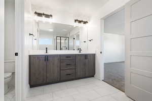 Bathroom with double vanity, a stall shower, light carpet, and light marble finish floors
