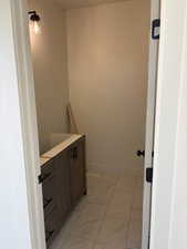 Bathroom featuring vanity and light marble finish floors