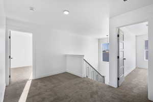 Corridor featuring carpet flooring and baseboards