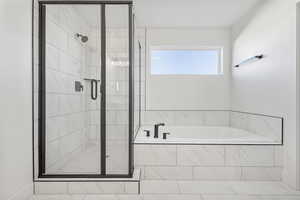 Full bath with a shower stall and a bath