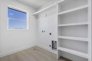 Laundry room with hookup for a washing machine, light wood-style floors, and electric dryer hookup